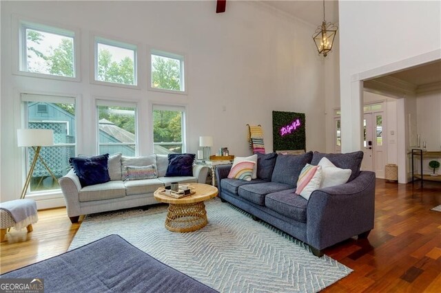 living room with dark hardwood / wood-style flooring, a high ceiling, and a chandelier