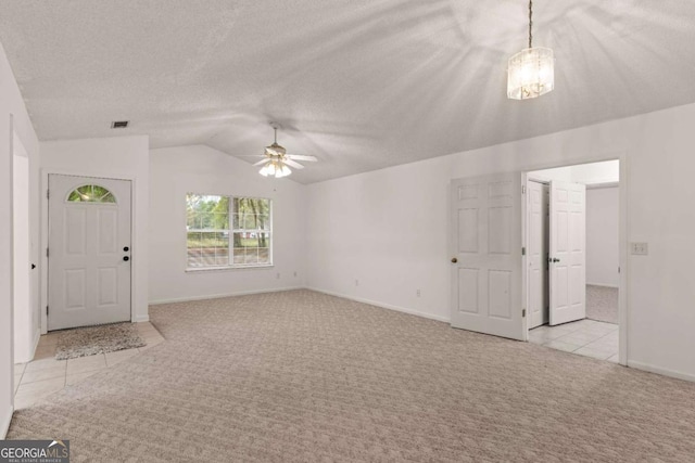 unfurnished living room featuring a textured ceiling, ceiling fan, lofted ceiling, and light carpet