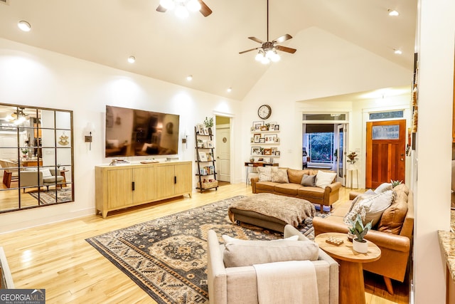 living room featuring ceiling fan, light wood-type flooring, and high vaulted ceiling