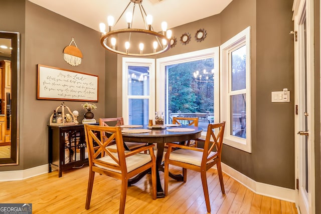 dining area with an inviting chandelier and light hardwood / wood-style floors