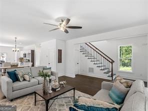 living room with ceiling fan with notable chandelier and hardwood / wood-style flooring