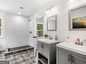 bathroom featuring tiled shower and vanity