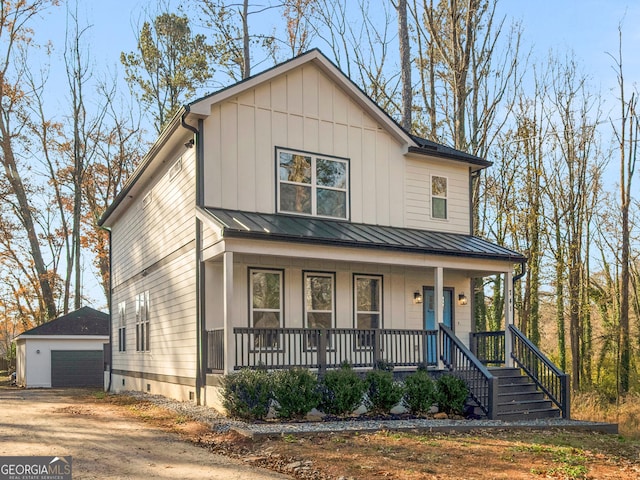 view of front of property featuring a porch, a garage, and an outbuilding