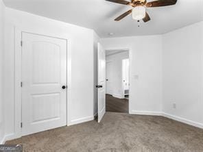 unfurnished bedroom with dark colored carpet and ceiling fan