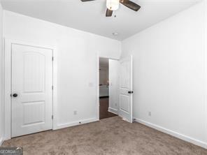 unfurnished bedroom with ceiling fan and light carpet