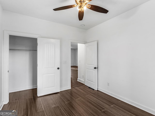 unfurnished bedroom with a closet, dark hardwood / wood-style floors, and ceiling fan