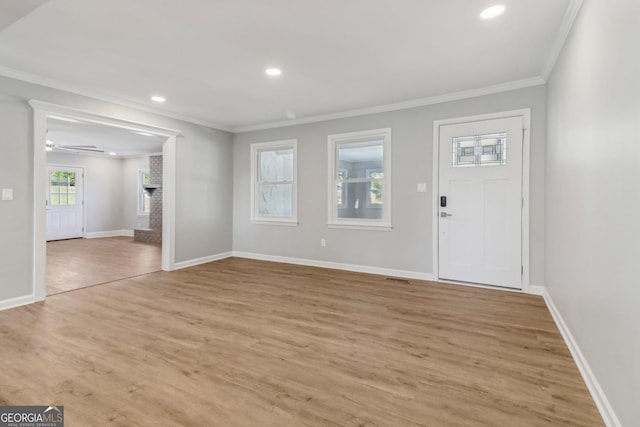 foyer featuring light hardwood / wood-style flooring, ceiling fan, and ornamental molding