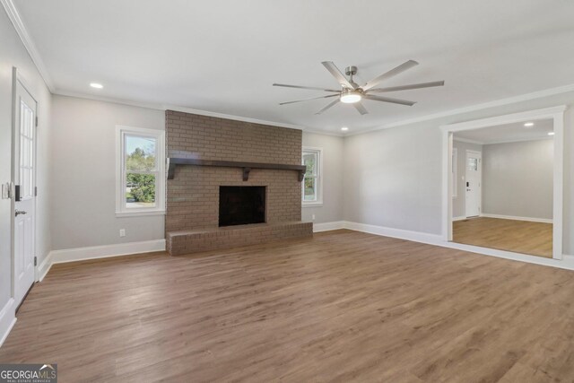 unfurnished living room featuring hardwood / wood-style flooring, a healthy amount of sunlight, and ornamental molding