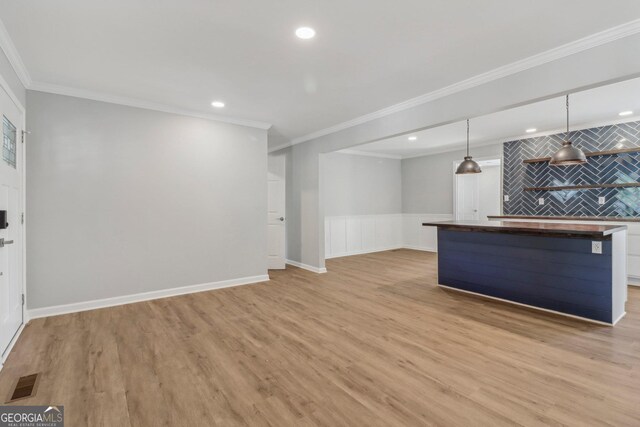 unfurnished living room featuring light wood-type flooring and ornamental molding