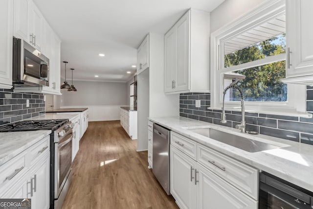 kitchen featuring light stone countertops, sink, white cabinetry, and stainless steel appliances