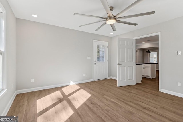 empty room with light hardwood / wood-style floors and ceiling fan