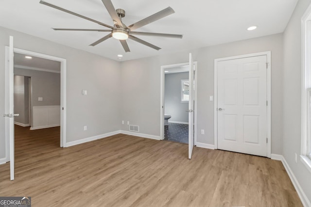 unfurnished bedroom featuring ceiling fan, light hardwood / wood-style floors, and connected bathroom