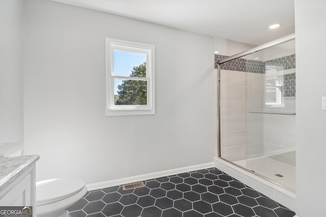 bathroom with vanity, toilet, and a shower with shower door