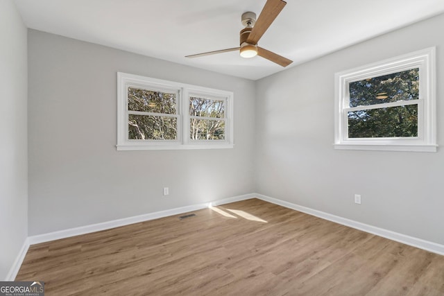 spare room with ceiling fan, plenty of natural light, and hardwood / wood-style flooring