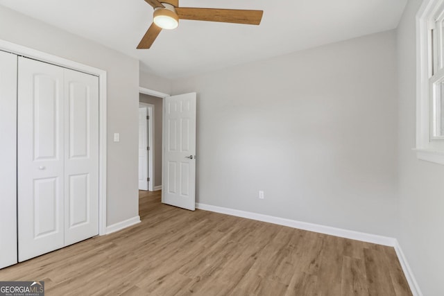 unfurnished bedroom with ceiling fan, a closet, and light wood-type flooring