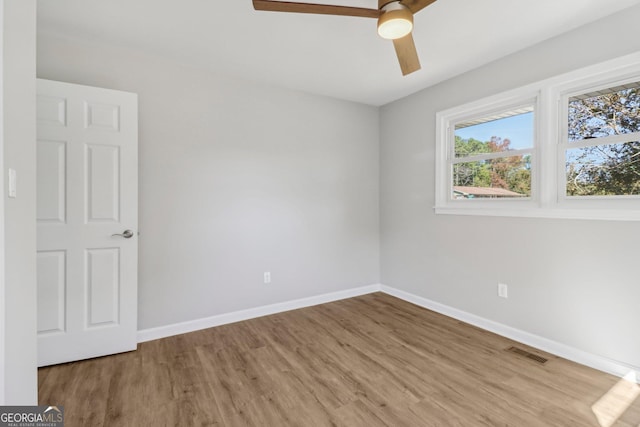 spare room with hardwood / wood-style floors and ceiling fan