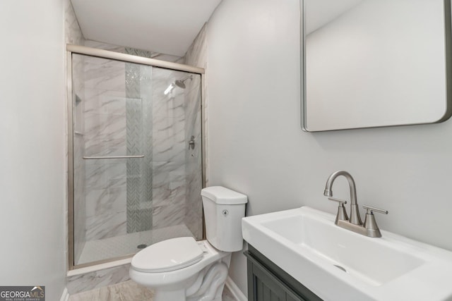 bathroom with a shower with door, vanity, and toilet