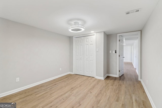 unfurnished bedroom with light hardwood / wood-style floors and a closet