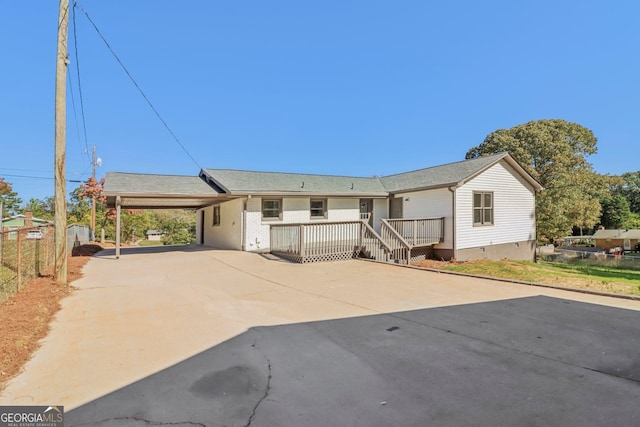 ranch-style house featuring a carport and a deck