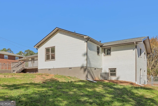 back of house featuring a lawn and a deck