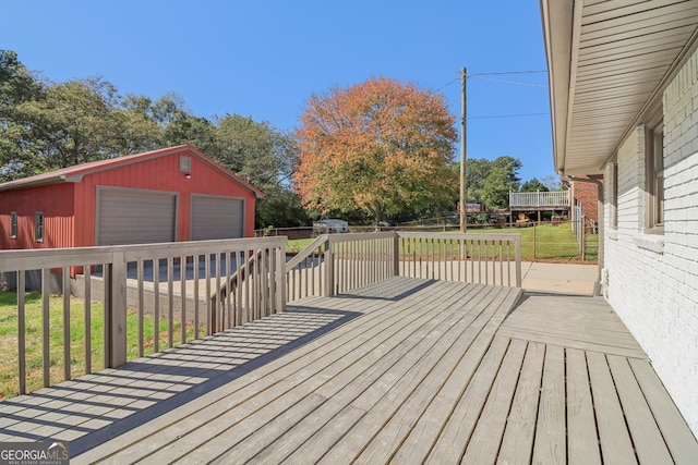 wooden deck with a lawn, a garage, and an outdoor structure