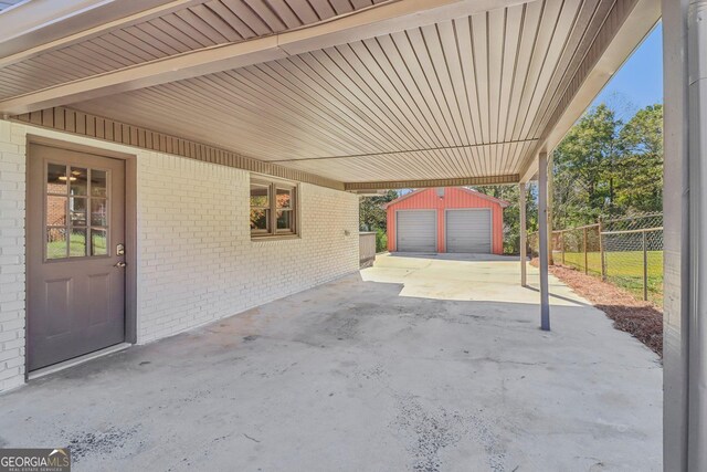 view of patio with an outbuilding and a garage