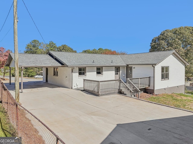 ranch-style home featuring a wooden deck and a carport