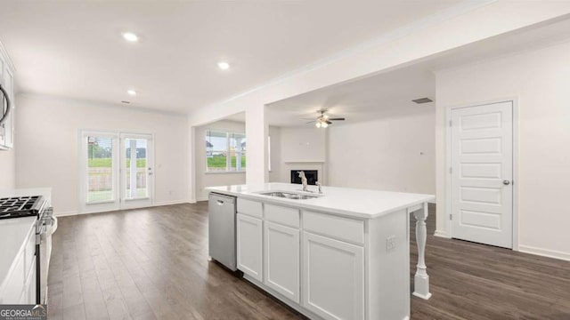 kitchen featuring stainless steel appliances, ceiling fan, sink, a center island with sink, and white cabinetry