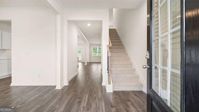 foyer entrance with crown molding and dark hardwood / wood-style floors