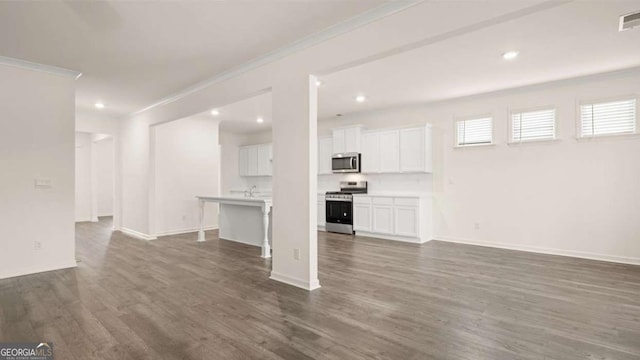 unfurnished living room featuring crown molding and dark wood-type flooring