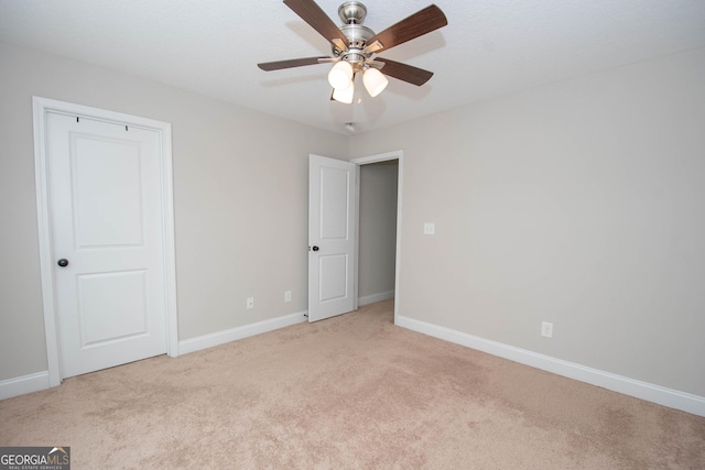 carpeted spare room with ceiling fan