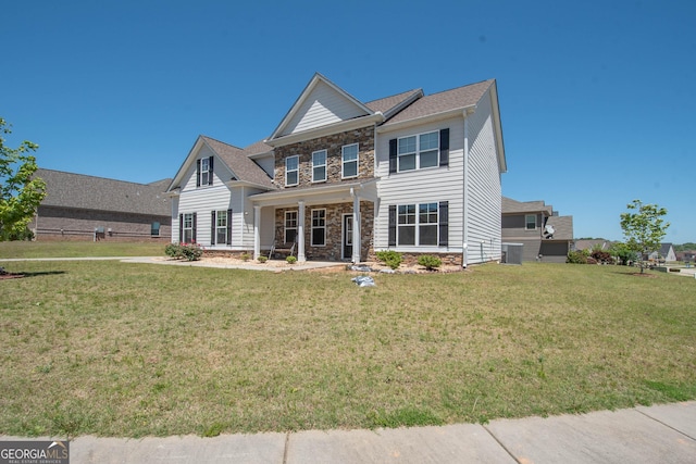 view of front of house featuring cooling unit and a front yard