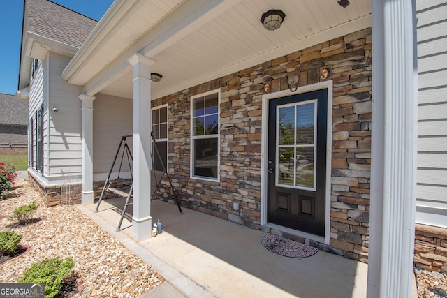 view of exterior entry featuring covered porch