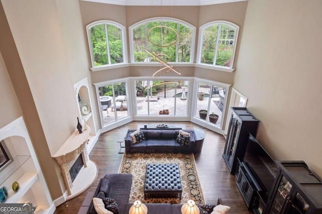 living room with a towering ceiling and dark wood-type flooring