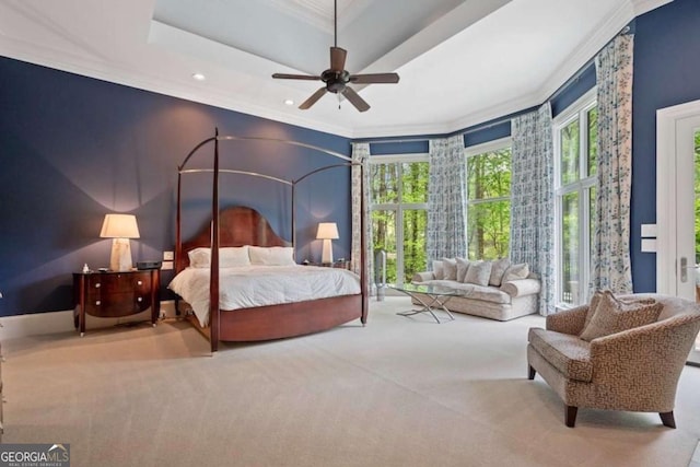 bedroom featuring carpet flooring, a raised ceiling, ceiling fan, and ornamental molding