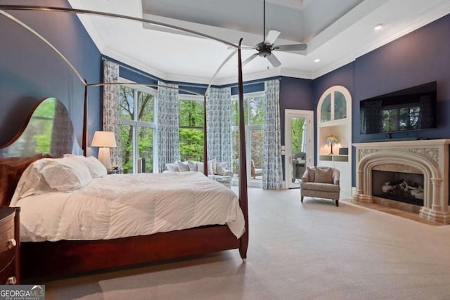 carpeted bedroom with access to exterior, ceiling fan, a towering ceiling, and ornamental molding