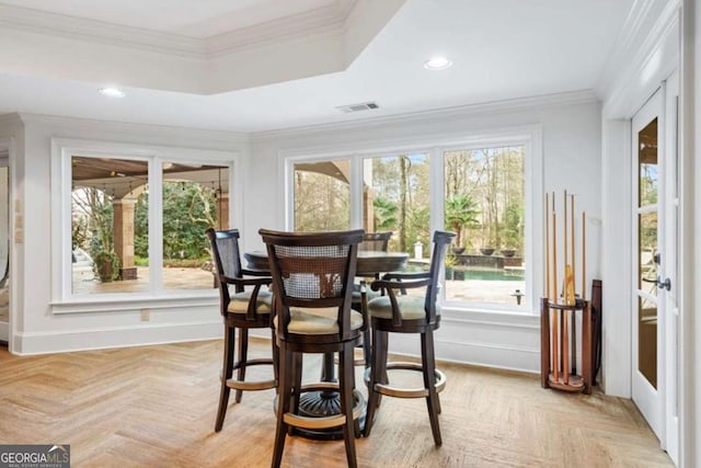 dining room featuring ornamental molding, a wealth of natural light, and light parquet flooring