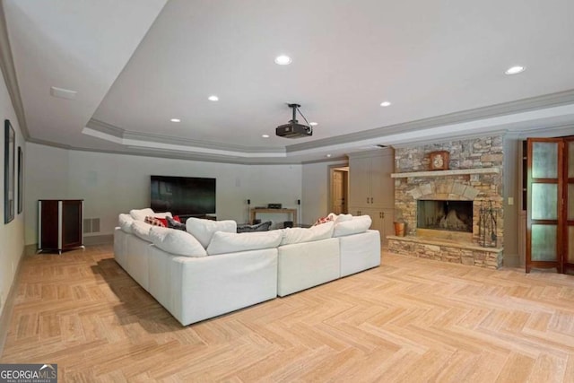 living room featuring a fireplace, light parquet flooring, a raised ceiling, and ornamental molding