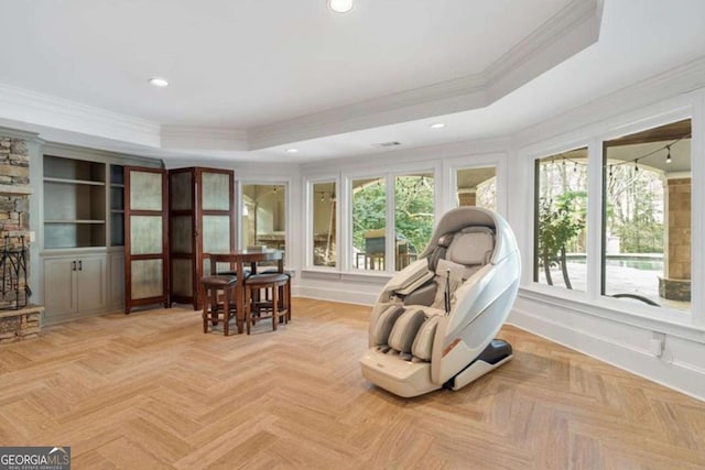 living area featuring a raised ceiling, ornamental molding, and light parquet floors