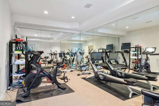 exercise room with carpet, a tray ceiling, and ornamental molding