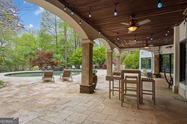 view of patio featuring ceiling fan and an outdoor bar