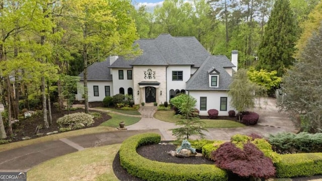 french provincial home with a front yard