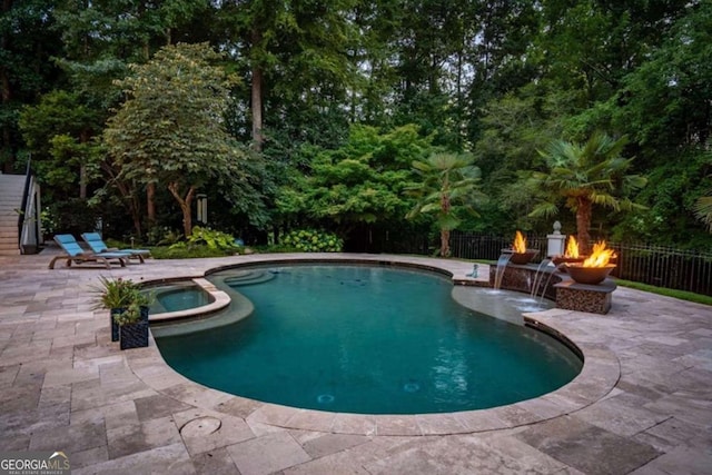 view of swimming pool featuring an in ground hot tub, a patio, and an outdoor fire pit