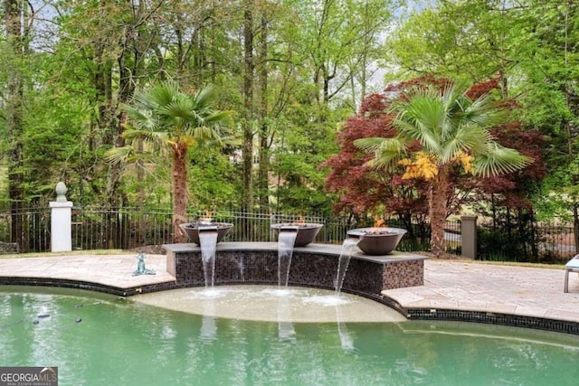 view of swimming pool with pool water feature