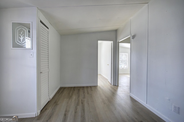 unfurnished room featuring light hardwood / wood-style floors and lofted ceiling