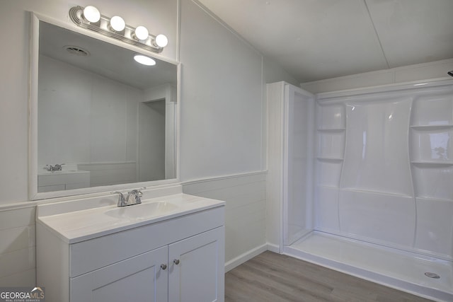 bathroom with vanity, wood-type flooring, and walk in shower