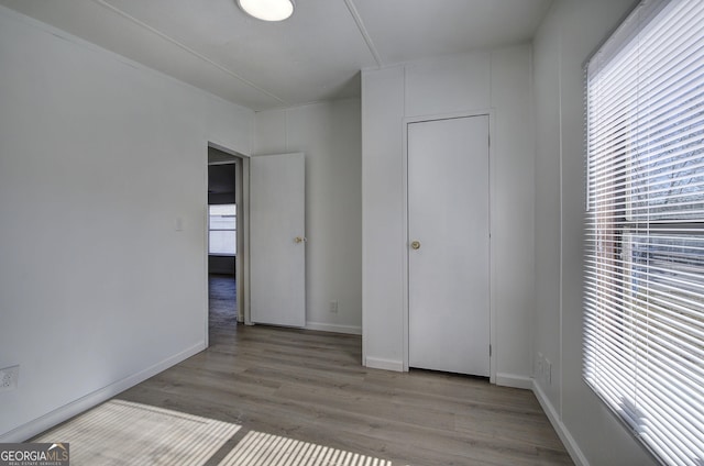 unfurnished bedroom featuring light hardwood / wood-style floors and multiple windows