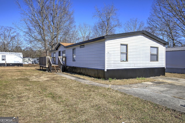 view of side of home featuring a lawn and a deck