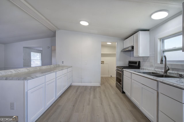 kitchen with white cabinetry, sink, stainless steel gas range oven, backsplash, and vaulted ceiling