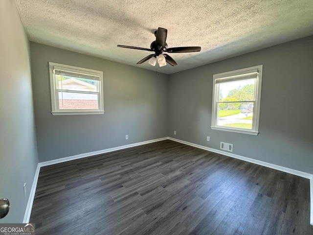 spare room featuring ceiling fan, dark hardwood / wood-style flooring, and a textured ceiling